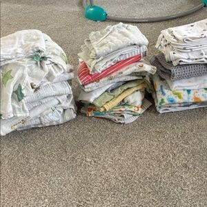 Assorted baby blankets, burp cloths, and swaddle blankets